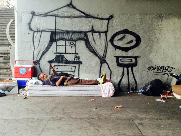 A street artist paints the dreams of homeless