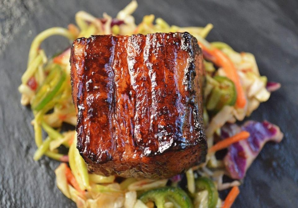 Slow Roasted Pork Belly Bites over Jalapeno Slaw