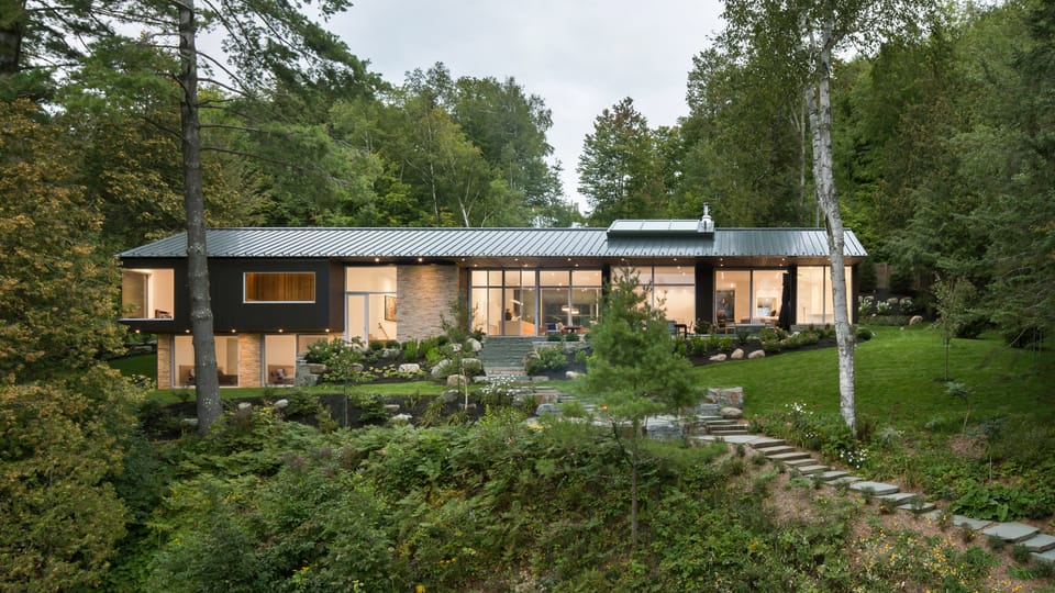 MU Architecture completes black lakefront home with two-storey boathouse